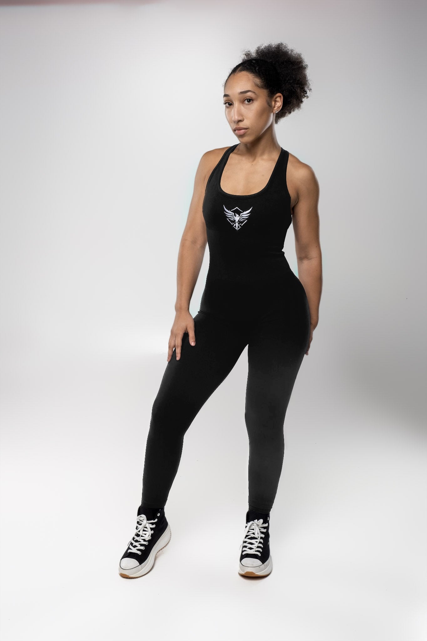 A woman in black workout gear striking a pose for a photo, showcasing her athletic style and confidence.